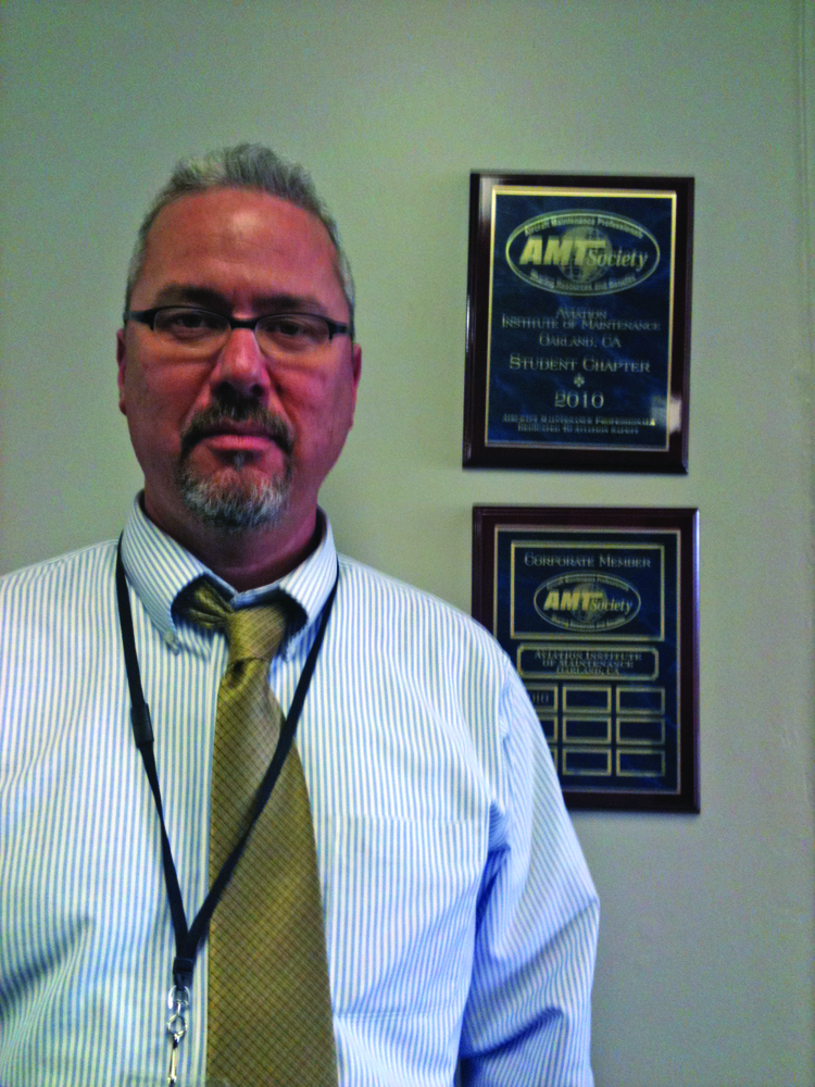 Joshua Smith, executive director, Aviation Institute of Maintenance Oakland Campus, receives a plaque for becoming an AMTSociety corporate member, the 10th AIM campus to do so.