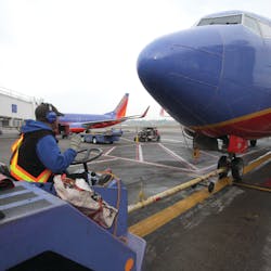 A Southwest Airlines tug operator uses Flightcom&apos;s wireless team communication system during a pushback at Portland International Airport