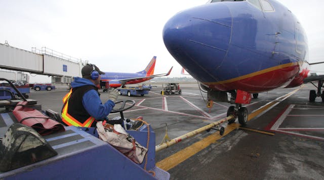 A Southwest Airlines tug operator uses Flightcom&apos;s wireless team communication system during a pushback at Portland International Airport