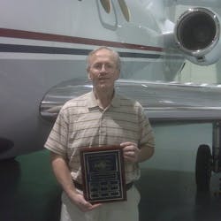 Gary S. Goodpaster accepted the plaque from AMTSociety; he is standing in front of the left wing of one of The Kroger Company&apos;s Falcon 50&apos;s.