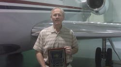 Gary S. Goodpaster accepted the plaque from AMTSociety; he is standing in front of the left wing of one of The Kroger Company&apos;s Falcon 50&apos;s.