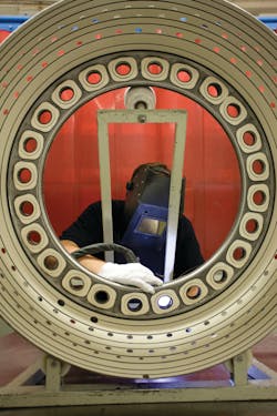 Technicians with Lufthansa Technik in Hamburg Germany use welding to repair the combustion chamber outer lining from a PW 4000 series engine.