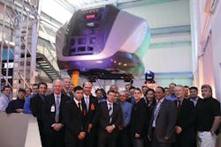 Airline customers and CAE employees at the inauguration of the revamped CAE Montreal training centre. In the background is the new CAE 5000 Series full-flight simulator for the Bombardier Q400 aircraft.