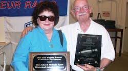 John and Melinda Lyon hold up John Lifetime Achievement Award and the plaque dedicating the Wathen Center&rsquo;s Library to the Lyons.