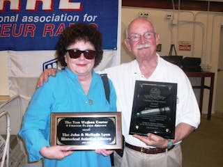 John and Melinda Lyon hold up John Lifetime Achievement Award and the plaque dedicating the Wathen Center&rsquo;s Library to the Lyons.