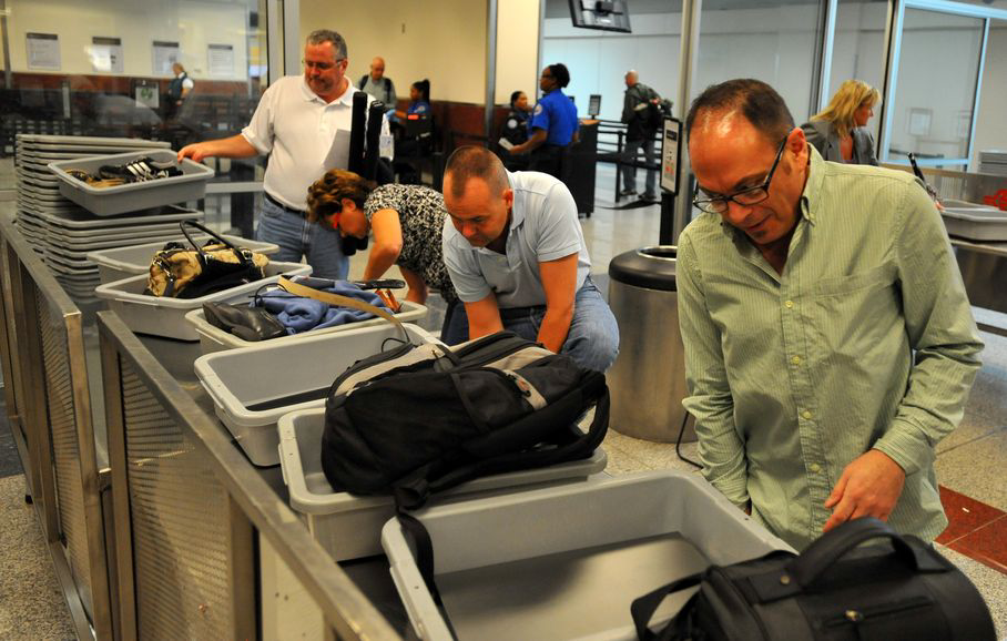 Travelers at Hartsfield-Jackson remove shoes and belts before passing through security. The TSA advises travelers to keep valuables with them as much as possible while going through security.