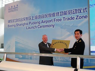Lin Hai, Deputy Director of Shanghai Customs, presenting the Free Trade Zone plaque to Boeing Shanghai CEO Dermot Swan.