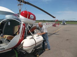 Scott Churchill readies a Model 47 prior to an aerial application flight. Scott Churchill readies a Model 47 prior to an aerial application flight.