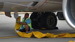A worker attaches a hose to carry pre-conditioned air to a jet at Seattle-Tacoma International Airport on Aug. 13, 2013. A worker attaches a hose to carry pre-conditioned air to a jet at Seattle-Tacoma International Airport on Aug. 13, 2013.