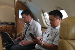 Elliott Aviation technicians Jon Young and Cuc Tan perform system checks on an Airshow 410 cabin management system in a Hawker 800XP.