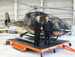 Vector's Regional Sales Director, Western Canada, Eric Hicks and Blackcomb's President and COO, Jonathan Burke shake hands in front of a Eurocopter EC130B4.