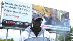 Delta skycap worker Hosea Wilcox in front of the billboard with his photo