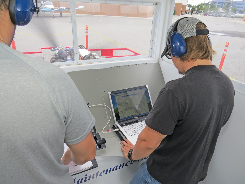 Students analyzing faults with a laptop on a FADEC diesel engine.