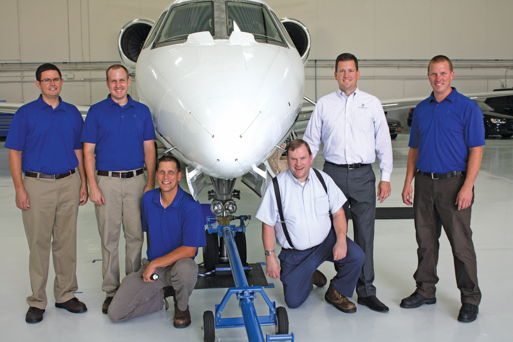 The General Mills corporate flight department includes technicians Derek Popp, Houston Kirkeide, Brad Sharp, custodian Paul Gunderson, aviation director Neil Brackin, Eric Olson, and Steve Schlesser (not pictured).