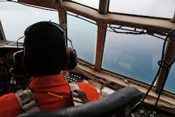 An Indonesian Air Force C-130 crew member scans the horizon during a search operation for the missing AirAsia Flight 8501 over the waters of Karimata Strait on Dec. 29.