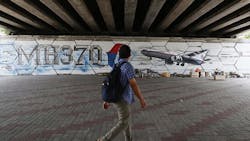 A man walks past graffiti depicting the missing Malaysia Airlines flight MH370 on the one year anniversary of its disappearance in Kuala Lumpur, on March 8, 2015. A man walks past graffiti depicting the missing Malaysia Airlines flight MH370 on the one year anniversary of its disappearance in Kuala Lumpur, on March 8, 2015.