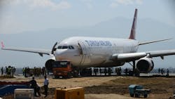 The nose of the Turkish Airlines plane rests on a flatbed tow truck several days after it slid off the tarmac at Kathmandu's international airport. The nose of the Turkish Airlines plane rests on a flatbed tow truck several days after it slid off the tarmac at Kathmandu's international airport.
