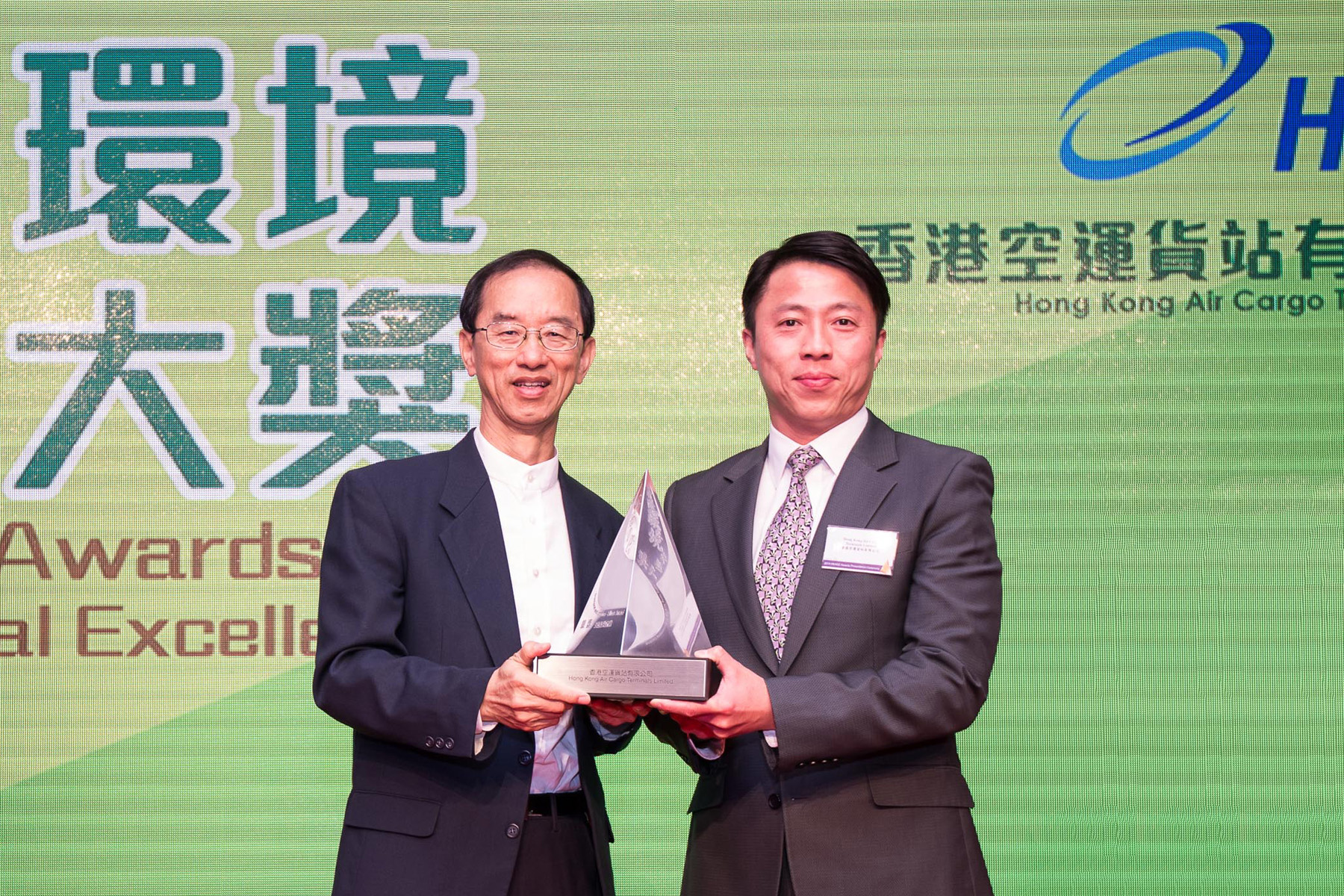 Hactl Executive Director Kenneth Chan (right) receives the trophy from Mr. Lam Chiu-ying, Chairman of the Environmental Campaign Committee.