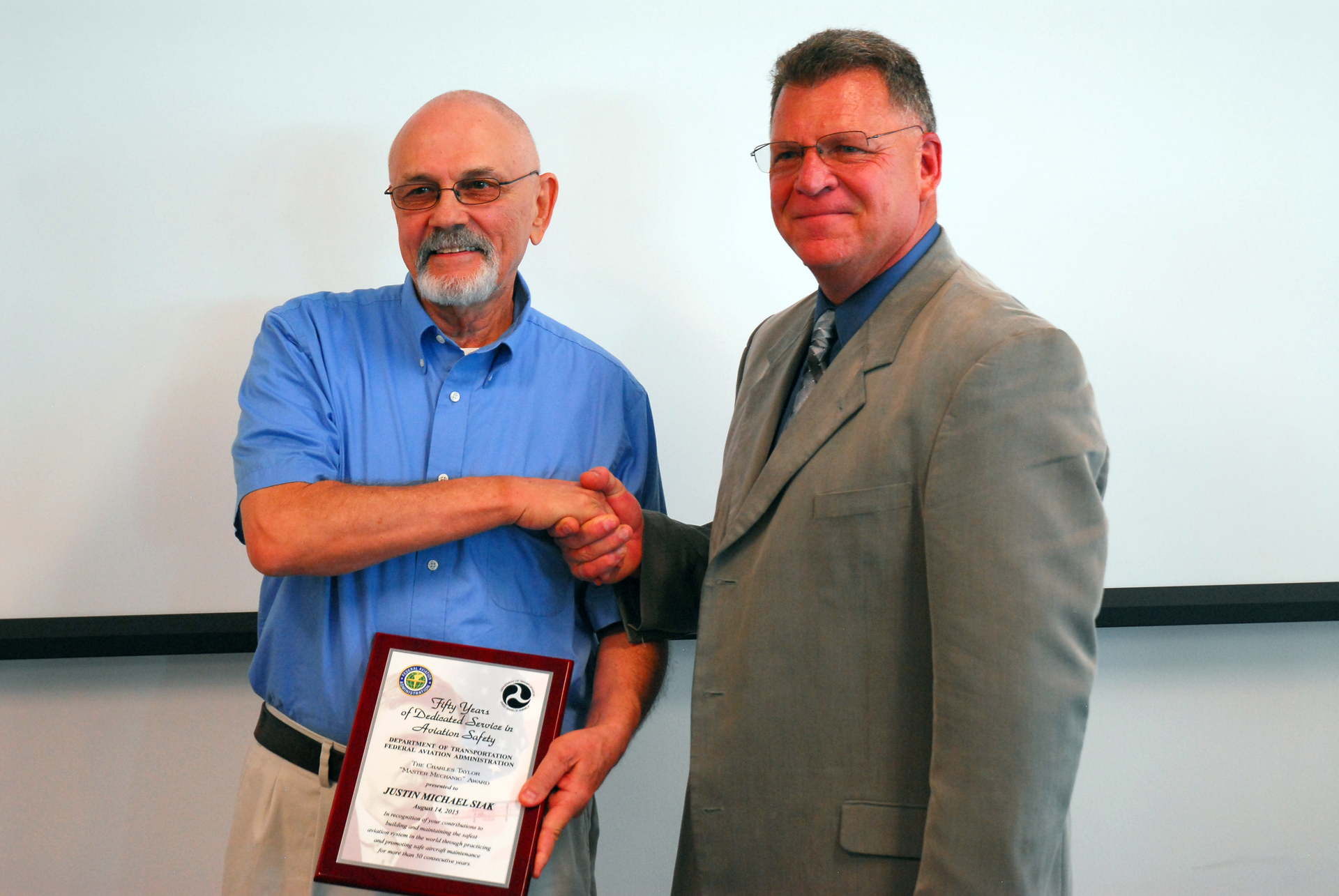 Justin receiving the award from Mark Harden