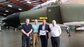 NEW ENGLAND AIR MUSEUM recognized PPG Aerospace for contributing coatings and technical guidance for the restoration of an F-4 Phantom fighter jet with a commemorative plaque presented to Kevin Lee, second from right, PPG senior account manager, aerospace. With him, from left, are Jerry Roberts, NEAM executive director; Jim McGuire, restoration technician and an NEAM volunteer; and Kim Jones, NEAM board member and volunteer. They are pictured in front of the restored F-4 fighter jet repainted with PPG coatings in its paint scheme from the Vietnam War.