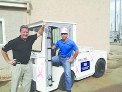 John Moore, senior vice president of sales and marketing, and Jamie Kaplan, president and CEO, Harlan Global Manufacturing, display an HLEPB pushback/cargo/bag tractor for US Airways Express painted with pink ribbons to mark Breast Cancer Awareness month during October.