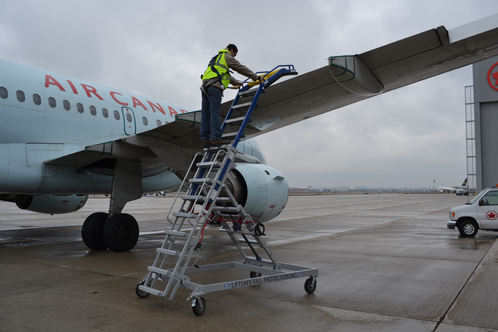 Working from a custom ladder, the technician has a restraint system to keep him from falling.