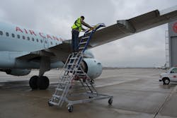 Working from a custom ladder, the technician has a restraint system to keep him from falling. Working from a custom ladder, the technician has a restraint system to keep him from falling.