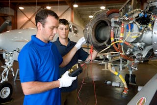 Vector technicians work on aircraft engine
