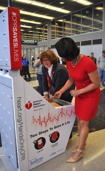 AHA Hands-Only CPR spokesperson Danielle DeVito, right, helps CDA Commissioner Ginger S. Evans learn how to use the CPR kiosk at O&apos;Hare.