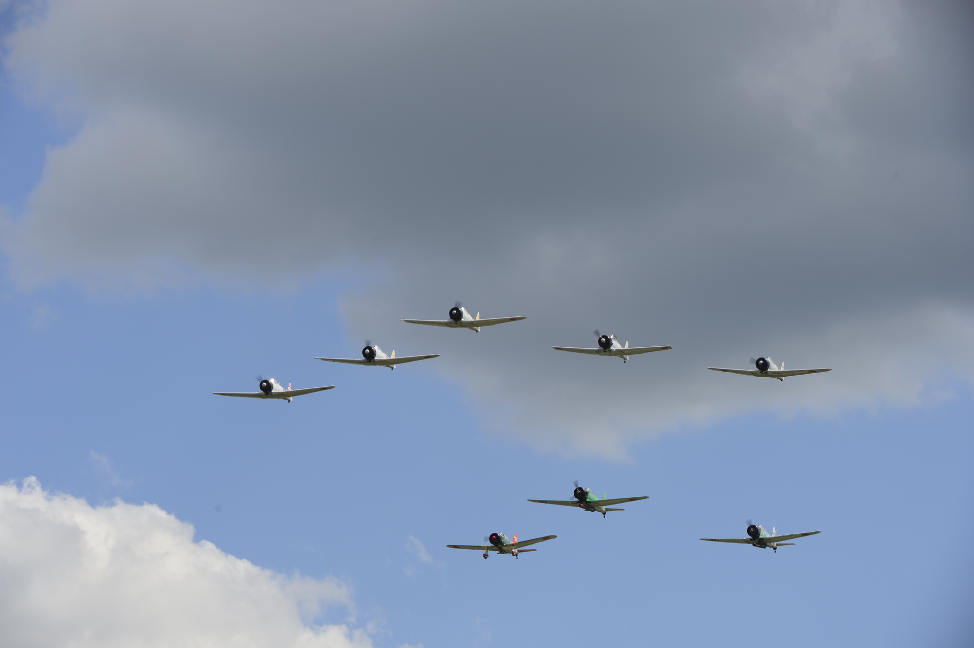 Vintage military aircraft in Japanese WWII markings fly during the performance of the Tora Tora Tora re-enactment of the Pearl Harbor attack. Flown during EAA AirVenture 2013.