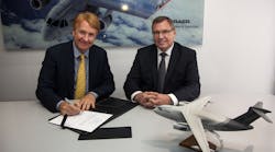 Jackson Schneider, president and CEO, Embraer Defense &amp; Security, and Ulrich Sasse, president of Rheinmetall Simulation and Training, sign the contract at FIDAE.