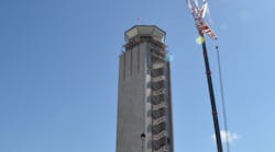 The south tower&rsquo;s cab glass is hoisted into position using a crane.