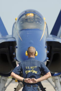 Petty Officer 1st Class Nathaniel Stuart, aviation ordnance man, crew chief for the U.S. Navy flight demonstration squadron, the Blue Angels, waits for a signal from his pilot at the Guardians of Freedom Air Show in 2011.