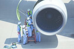 ANA maintenance personnel inspecting an airliner turbofan engine.