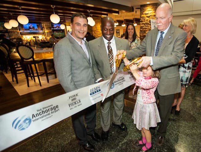 Cutting the ribbon, left to right: Stephen Douglas, vice president of business development, HMSHost; Javier Robinson, concessions manager, Ted Stevens Anchorage International Airport.; John Parrott, airport manager, Ted Stevens Anchorage International Airport.