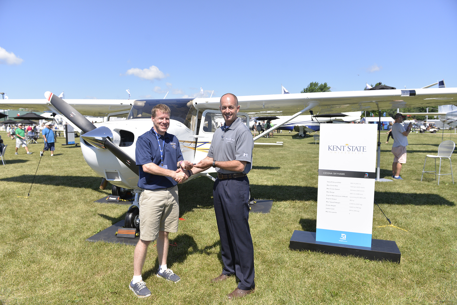 Doug May, vice president of Piston Aircraft presents Skyhawk keys to Stephen Pfanner, Kent State University chief flight instructor at Textron Aviation's static display at the Experimental Aircraft Association (EAA) AirVenture.