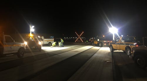 Airfield Maintenance employees working on an in-pavement flush mounted runway touchdown zone light.
