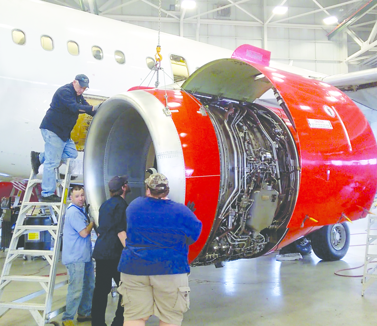 The newly installed TC/American crane shown here raising an engine cowl (right) is custom designed to meet the building and application requirements.