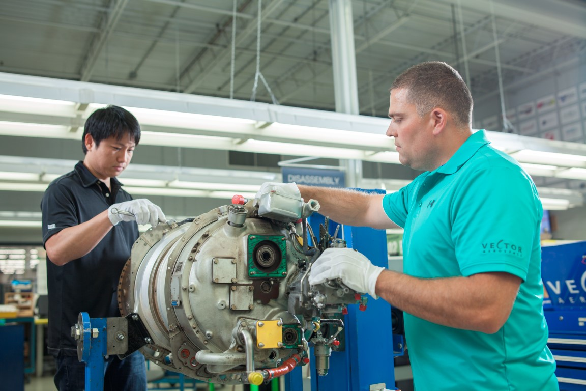 Vector technicians work on aircraft engine
