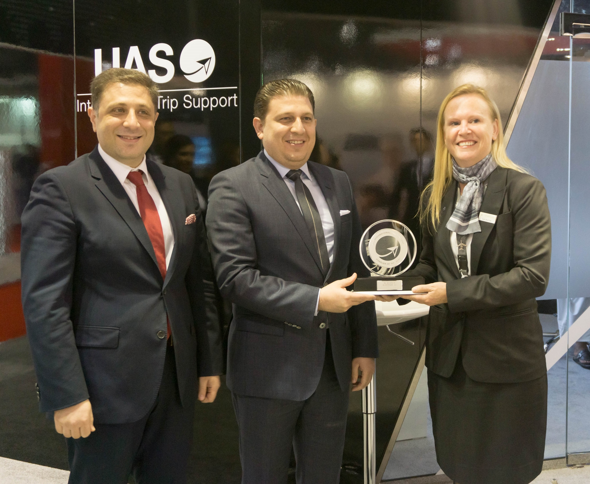 Susan Bujtas, operations manager at DCAF receives the award from Omar Hosari, UAS co-owner/founder and CEO (left) and Mohammed Husary, UAS co-owner/founder and executive president (middle).