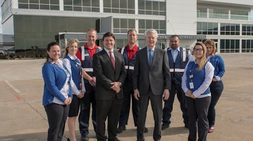 Employees of American Aero FTW, a fixed-base operator (FBO) at Meacham International Airport in Fort Worth, surround general manager Riggs Brown (center left) and owner Robert M. Bass (center right) as the team celebrates the grand opening of the private aviation terminal&rsquo;s new facility, designed to attract travelers from around the country and across the globe.