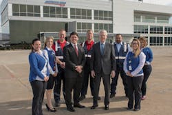 Employees of American Aero FTW, a fixed-base operator (FBO) at Meacham International Airport in Fort Worth, surround general manager Riggs Brown (center left) and owner Robert M. Bass (center right)