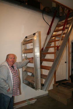 Buboltz stands beside the only access to his attic. Use of a Schweiss engineered lifting staircase opens and closes the staircase to give him additional space inside his garage.