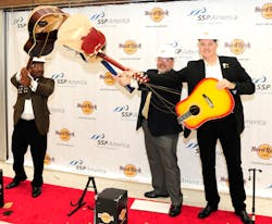 Capping the rollout of an expansive and exciting new lineup of dining and shopping choices at Bush Airport, representatives from the airport system, Hard Rock International and operator and manager, SSP America, were on hand and capped the celebration with a ceremonial “guitar smash.” Capping the rollout of an expansive and exciting new lineup of dining and shopping choices at Bush Airport, representatives from the airport system, Hard Rock International and operator and manager, SSP America, were on hand and capped the celebration with a ceremonial “guitar smash.”