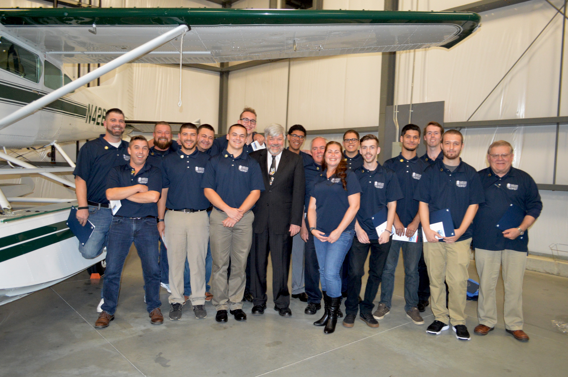 President Cox (center) is surrounded by very happy graduates immediately after receiving their program completion certificates and program pins from their faculty.