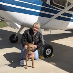 Susan Dusenbury with her dog, Taylor. That&apos;s her 1953 Cessna 180 in the background.
