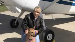 Susan Dusenbury with her dog, Taylor. That's her 1953 Cessna 180 in the background.