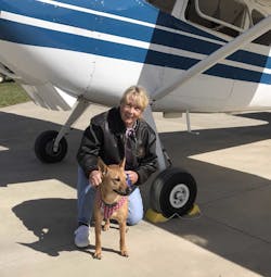 Susan Dusenbury with her dog, Taylor. That&apos;s her 1953 Cessna 180 in the background.