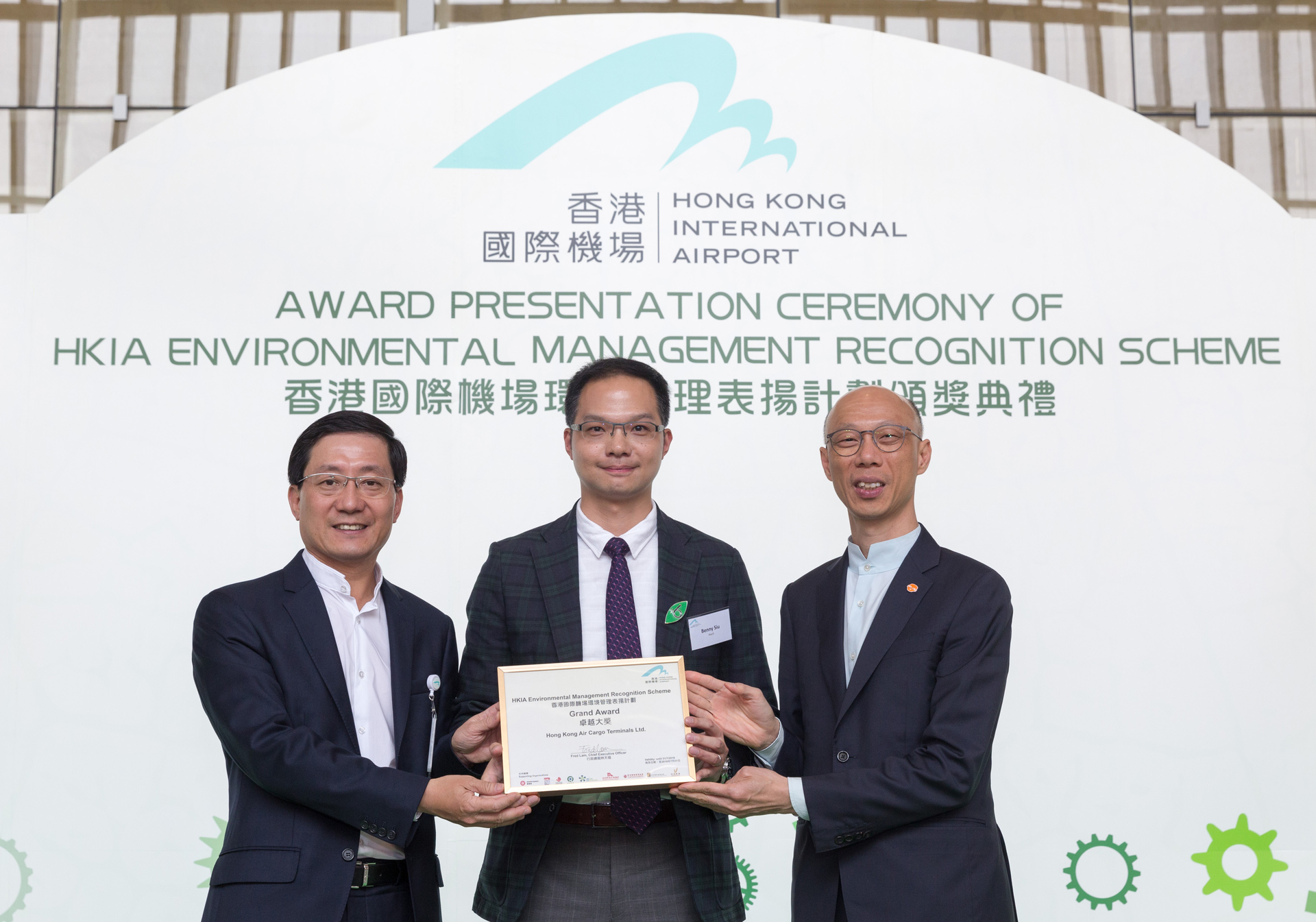 Benny Siu, Hactl&rsquo;s Senior Manager &ndash; Quality Assurance, receives the award from Mr. Fred Lam, Chief Executive Officer of Airport Authority Hong Kong (left) and Mr. Wong Kam-sing, Secretary for the Environment (right).