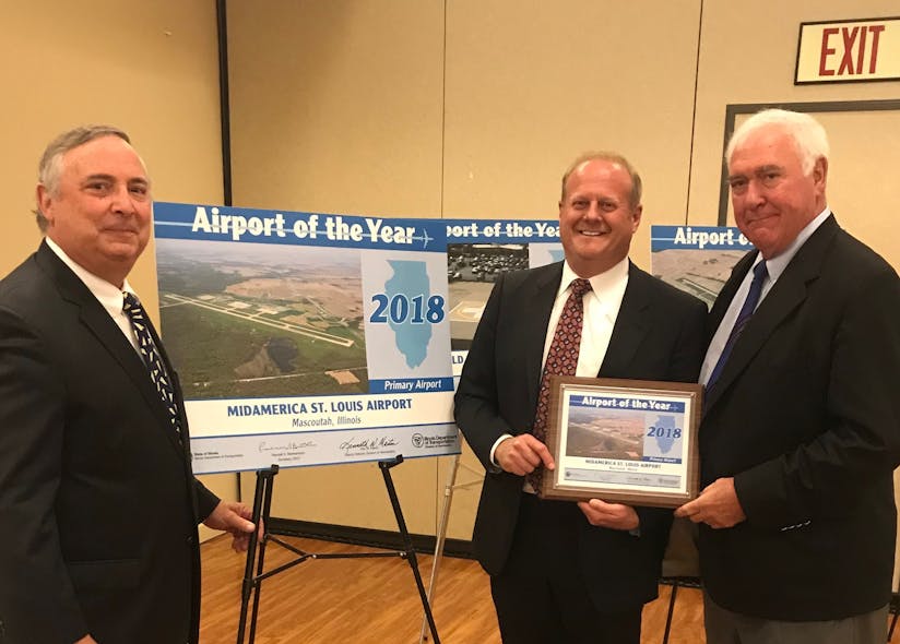 MidAmerica St. Louis Airport Director Tim Cantwell, St. Clair County Chairman Mark Kern and Rich Sauget, Chair of The Public Building Commission of St. Clair County pause for a photo by the signage recognizing MidAmerica St. Louis Airport&rsquo;s selection by the Illinois Department of Transportation&rsquo;s Division of Aeronautics as the 2018 Primary Airport of the Year. The award was presented at a special luncheon ceremony on Thursday, May 24, during the Illinois Aviation Conference in Springfield, Ill.